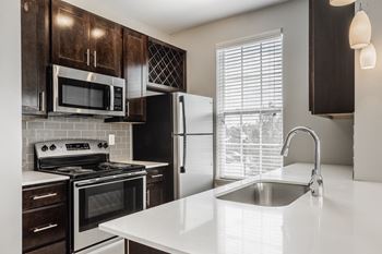 A kitchen with a white countertop and black appliances